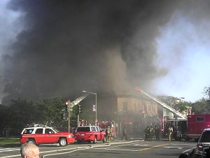 Smoke envelopes the building as fire officials arrive
