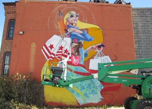 Mural promoting local shopping overlooks the building site. 