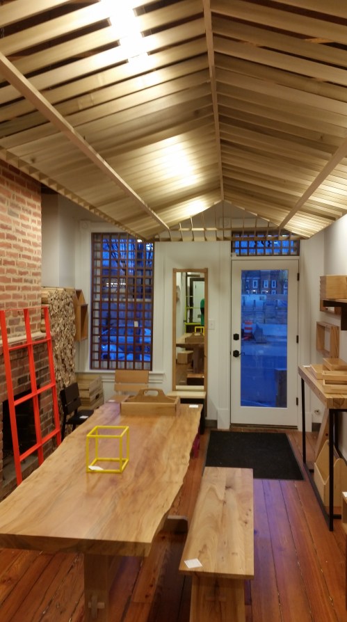 septcarrés' showroom is still in the process of coming together.  The decorative ceiling installation is a highly crafted 1/3 scale model of a hip roof.  The single slab table was custom built for the space.